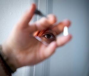 Close-up of eye reflecting in broken mirror