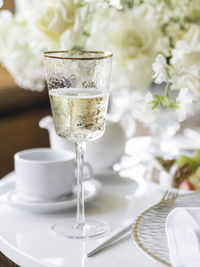 Table serves for banquet. champagne in modern stylish wine glass, plates with napkins and cutlery