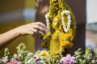 Close-up of hand holding yellow flowers