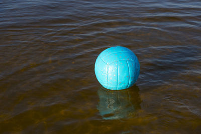 Water polo yellow ball on sea with splash