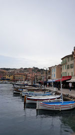 Boats moored in river against buildings in city