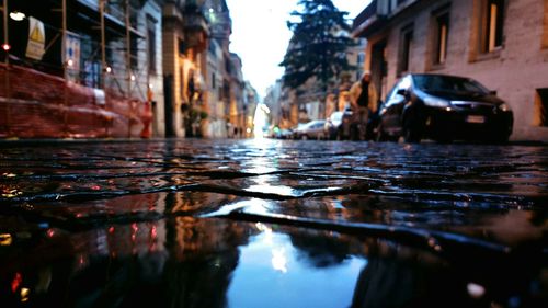 Street journals- reflection of buildings on a pebble stone road after rain