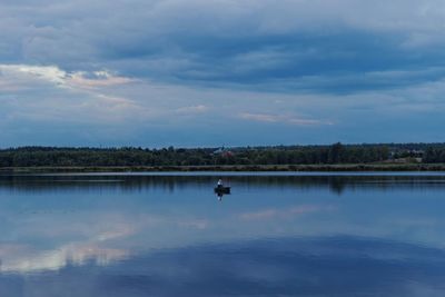 Scenic view of calm lake against cloudy sky