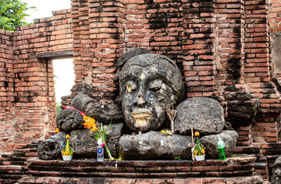 Statue against brick wall of building