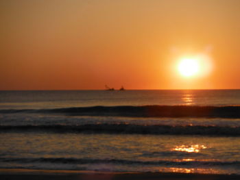 Scenic view of sea against orange sky