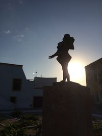 Low angle view of silhouette statue against sky