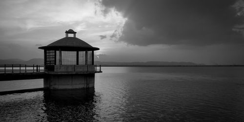 Lighthouse by sea against sky