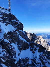 Scenic view of snowcapped mountains against blue sky