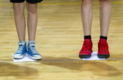 Low section of boys standing on hardwood floor