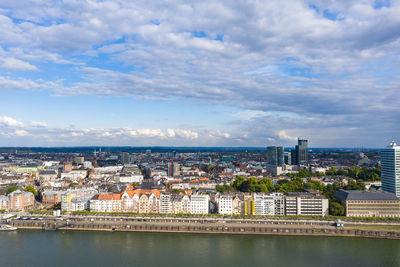 River amidst buildings in city against sky