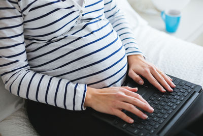 Midsection of woman using mobile phone