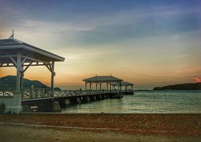 Pier at beach during sunset