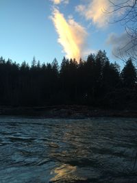 Scenic view of river against sky at sunset