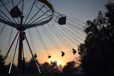 Low angle view of silhouette ferris wheel against sky at sunset