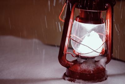 Close-up of electric lamp on table against wall