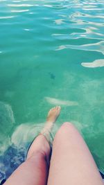 Low section of woman sitting in swimming pool