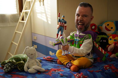 Happy boy sitting on bed at home