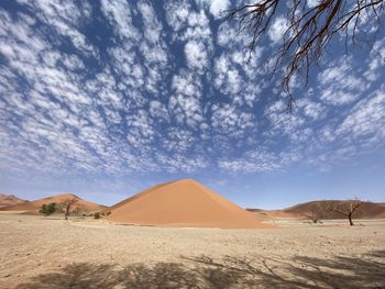 Scenic view of desert dune against sky