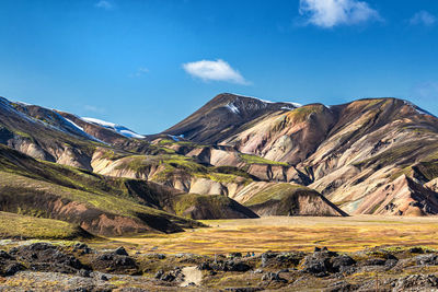 Scenic view of mountains against blue sky