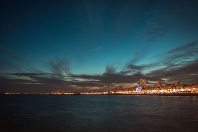 Illuminated city at waterfront at night