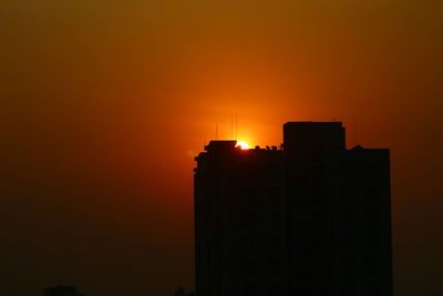 Low angle view of silhouette buildings against sky during sunset