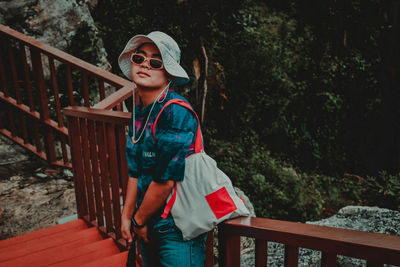 Portrait of young woman standing on footbridge