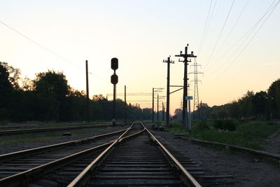 Railroad tracks against sky during sunset