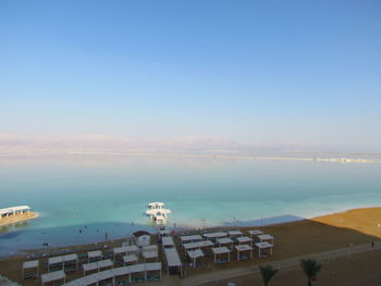 High angle view of buildings by sea against clear sky