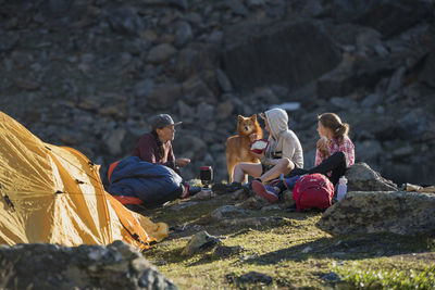 Mother with kids relaxing near tent