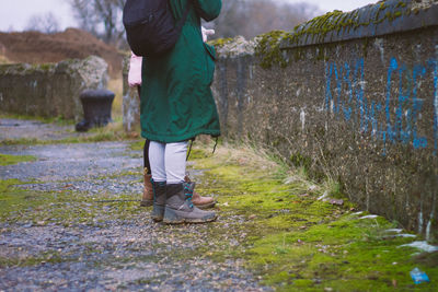 Low section of friends standing on moss covered road