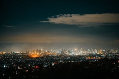 Illuminated city buildings against sky at night