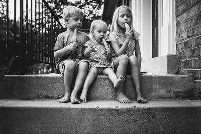 Full length of girl sitting outdoors