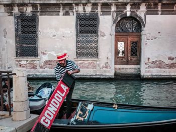 Side view of man on boat against building