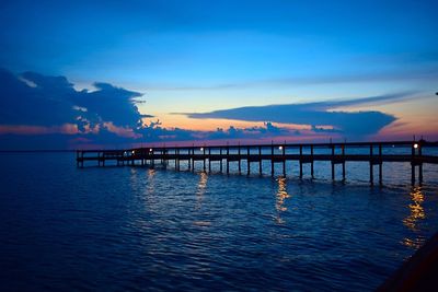 Pier on sea at sunset