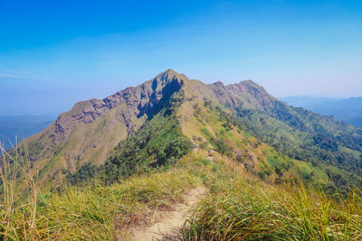 Scenic view of mountains against blue sky