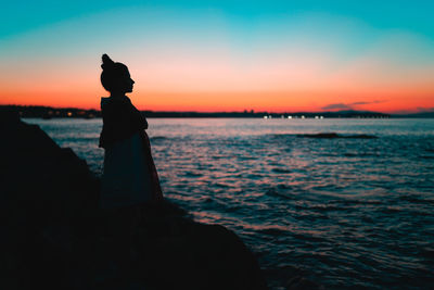 Silhouette man on beach against sky during sunset