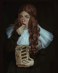 Portrait of woman against black background