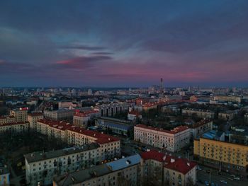 High angle view of city buildings against cloudy sky