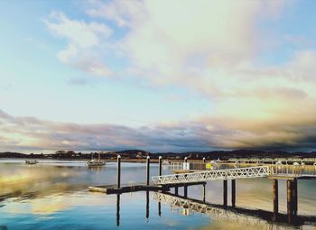 Bridge over river against sky in city