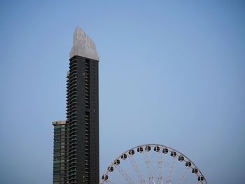 Low angle view of ferris wheel against buildings