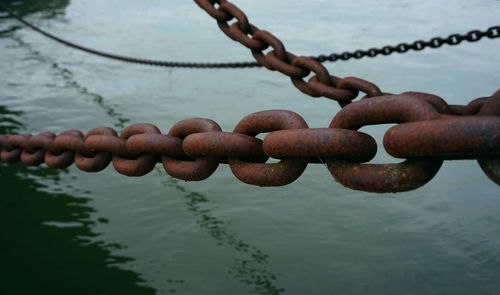 Close-up of rusty chain over sea