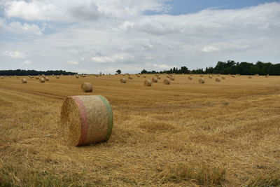 Hay bales on field against sky