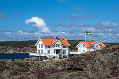 Houses by sea and buildings against sky