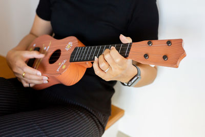 Midsection of woman playing guitar