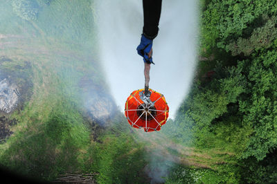 Low section of man standing by water on land