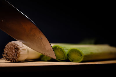 Close-up of green leaves on table against black background