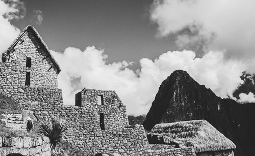 Low angle view of ruined building against cloudy sky