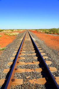 Railroad track against clear blue sky