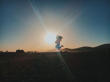 Man standing on land against sky during sunset