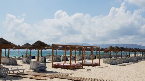 Chairs on beach against sky